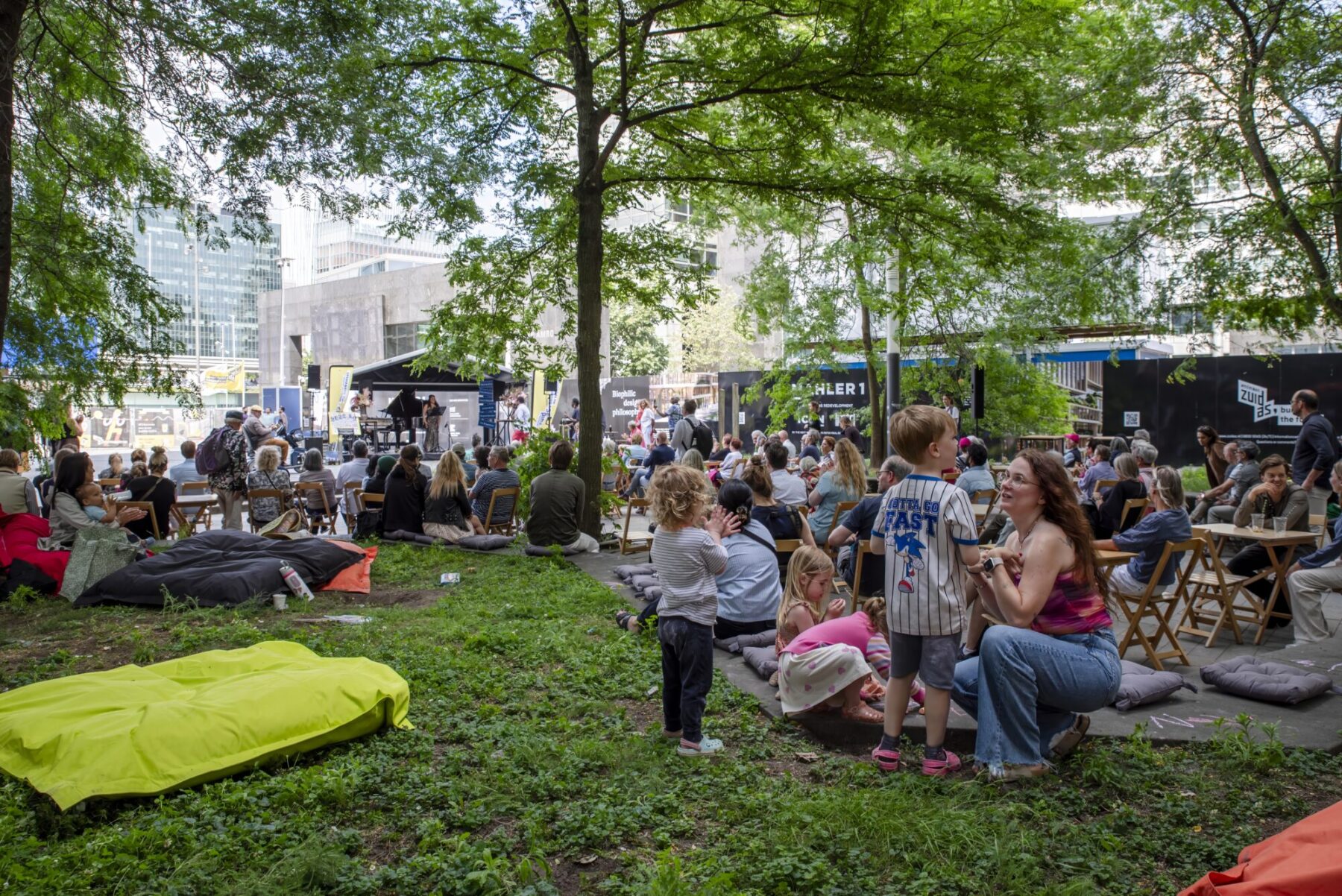 Mensen op het Mahlerplein die luisteren naar muziek